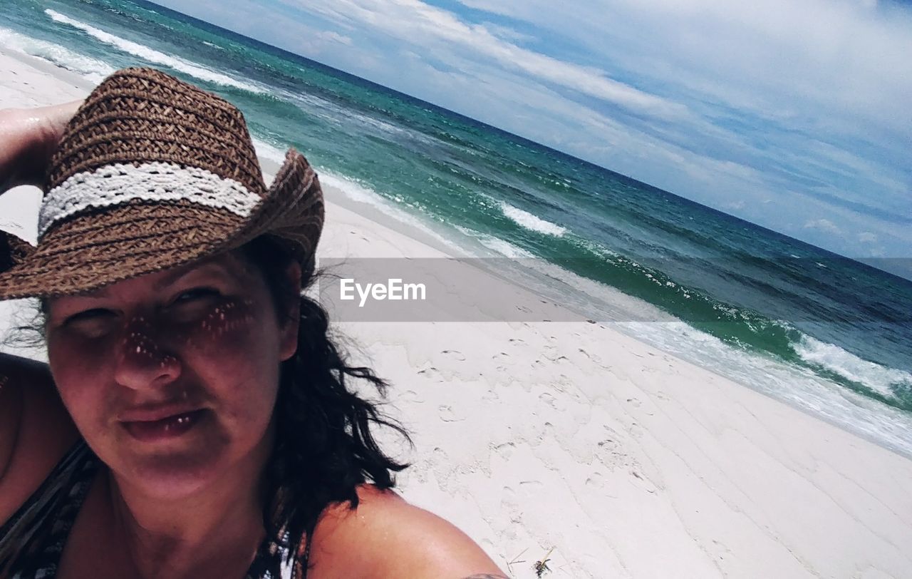 PORTRAIT OF SENIOR WOMAN ON BEACH