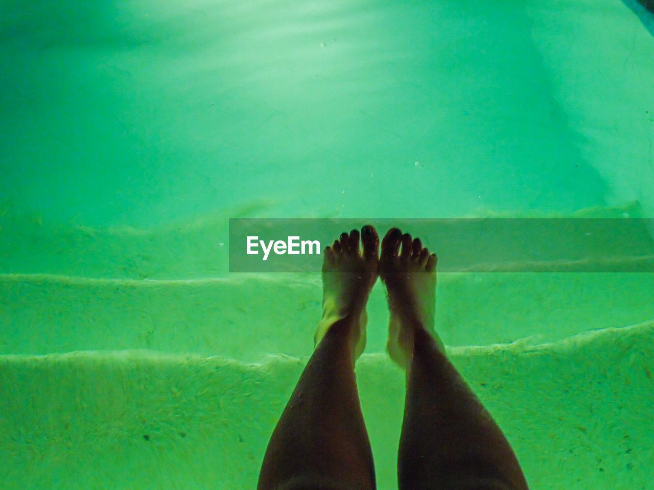 LOW SECTION OF WOMAN FEET ON BEACH