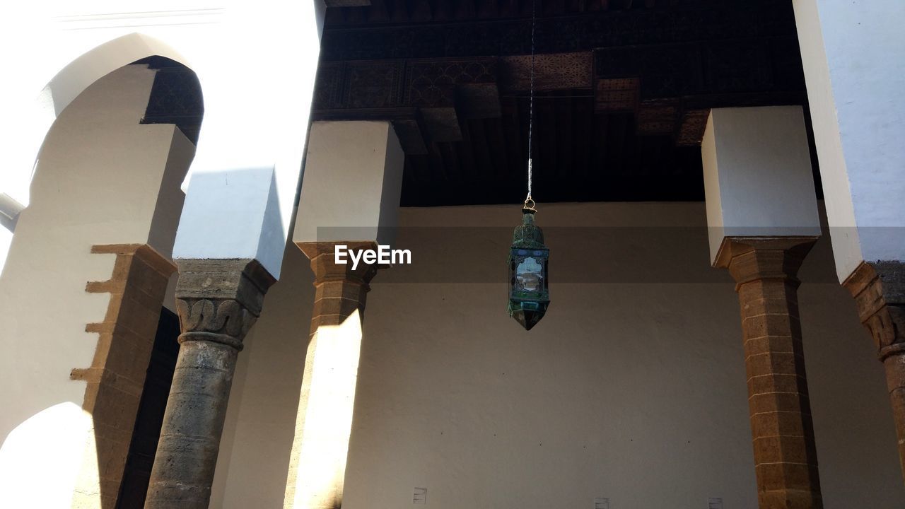 LOW ANGLE VIEW OF DECORATIONS HANGING ON BUILDING AGAINST SKY