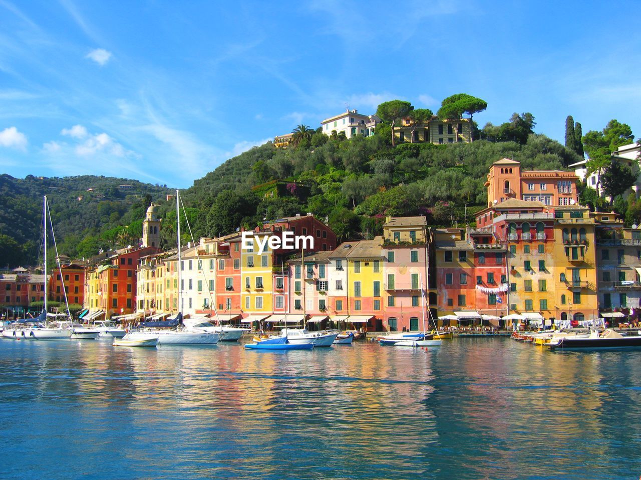 BOATS IN SEA WITH BUILDINGS IN BACKGROUND