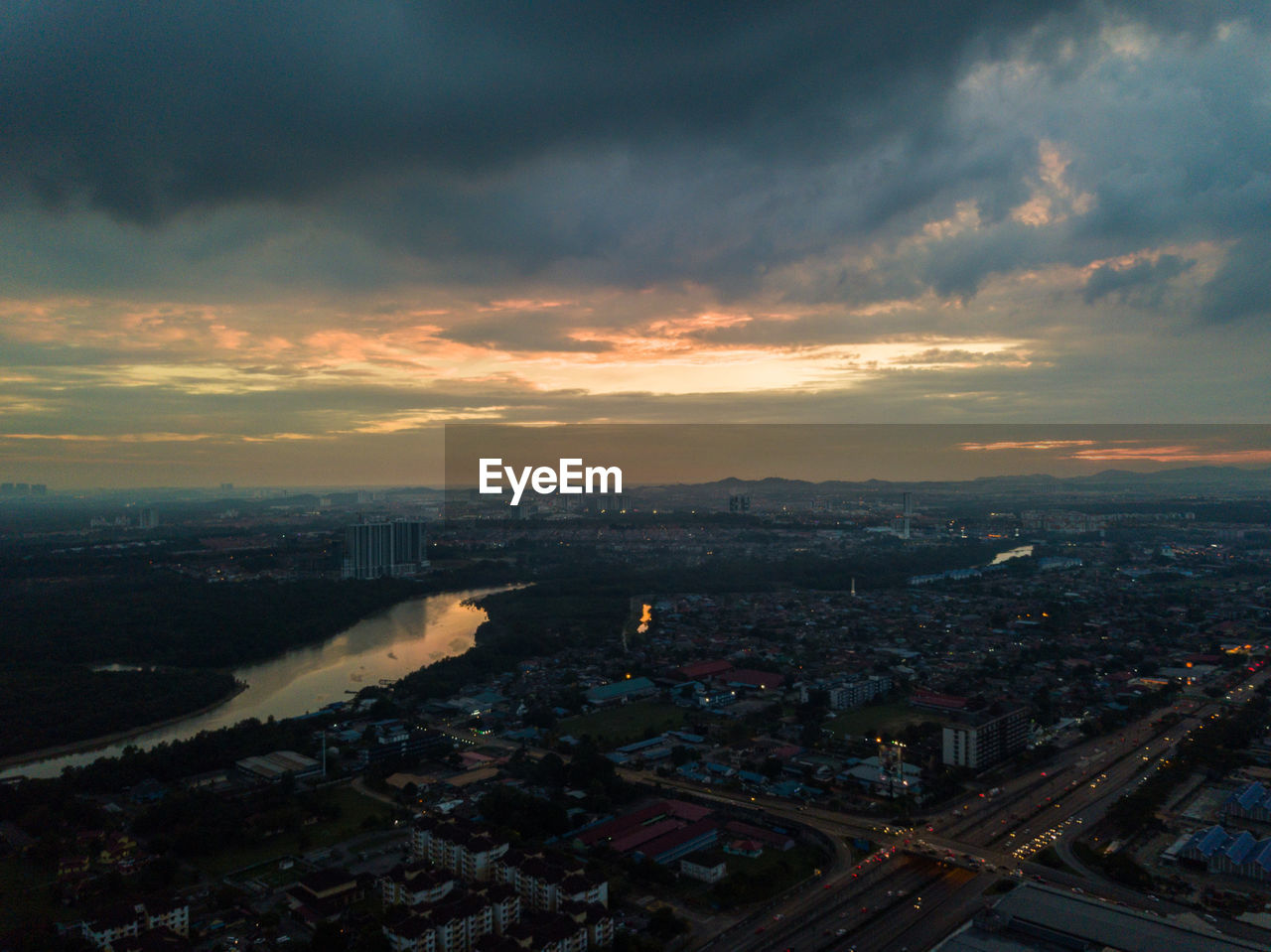 HIGH ANGLE VIEW OF BUILDINGS IN CITY AGAINST SKY AT SUNSET