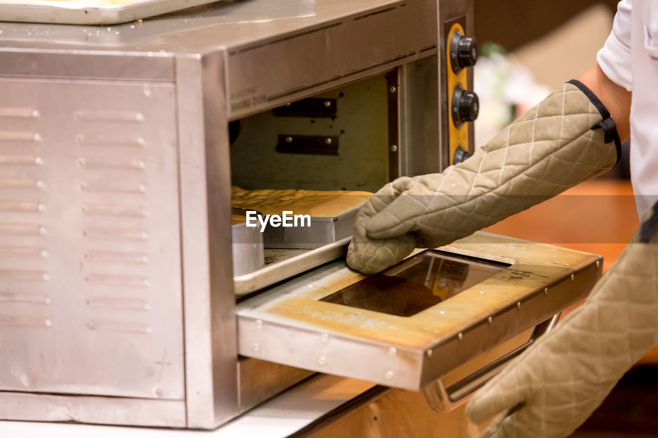 Midsection of man working in kitchen