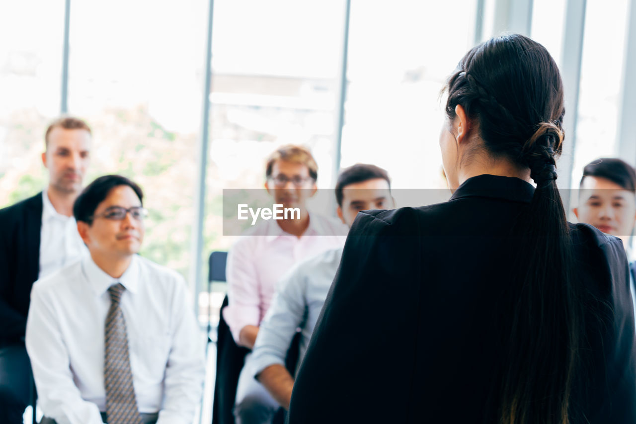 Businesswoman discussing with colleagues during meeting at office