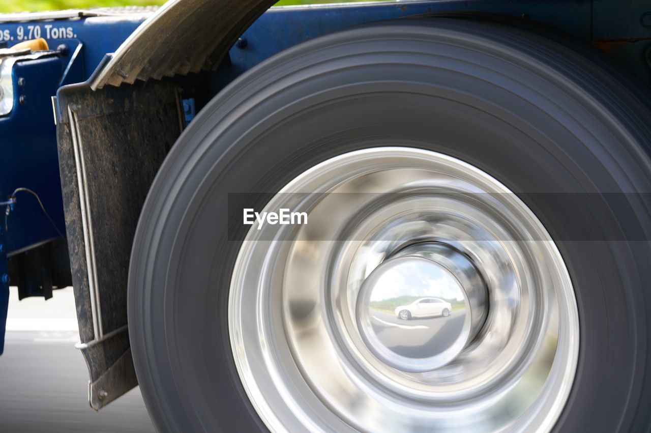 EXTREME CLOSE UP OF METAL WHEEL AND CAR