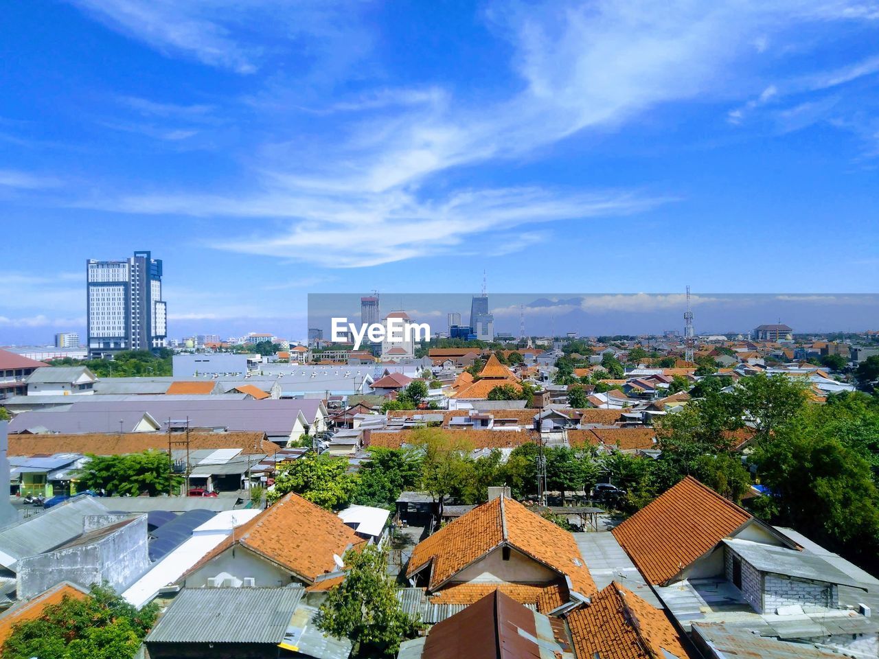 HIGH ANGLE VIEW OF BUILDINGS IN CITY AGAINST BLUE SKY