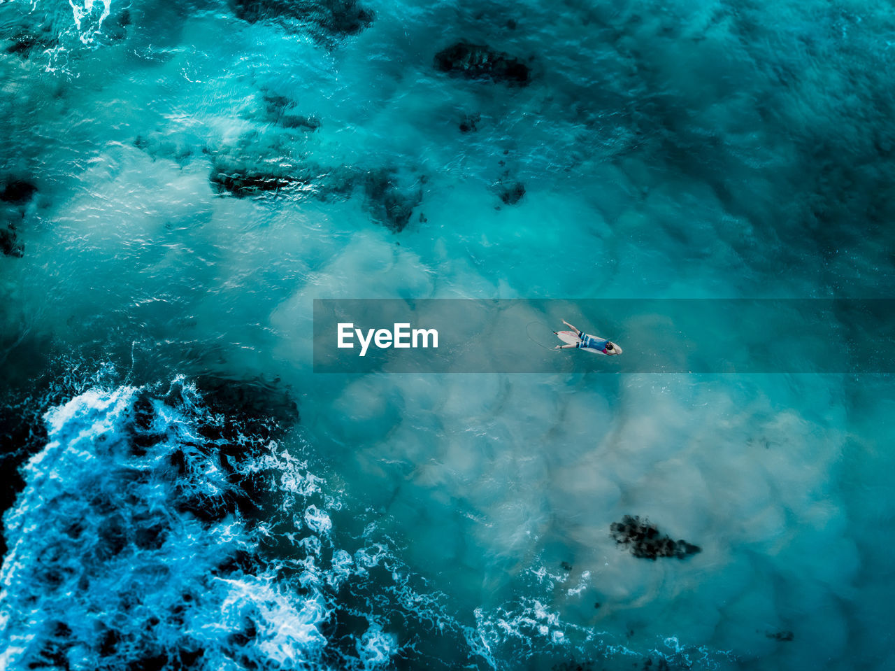 HIGH ANGLE VIEW OF WOMAN SWIMMING IN SEA