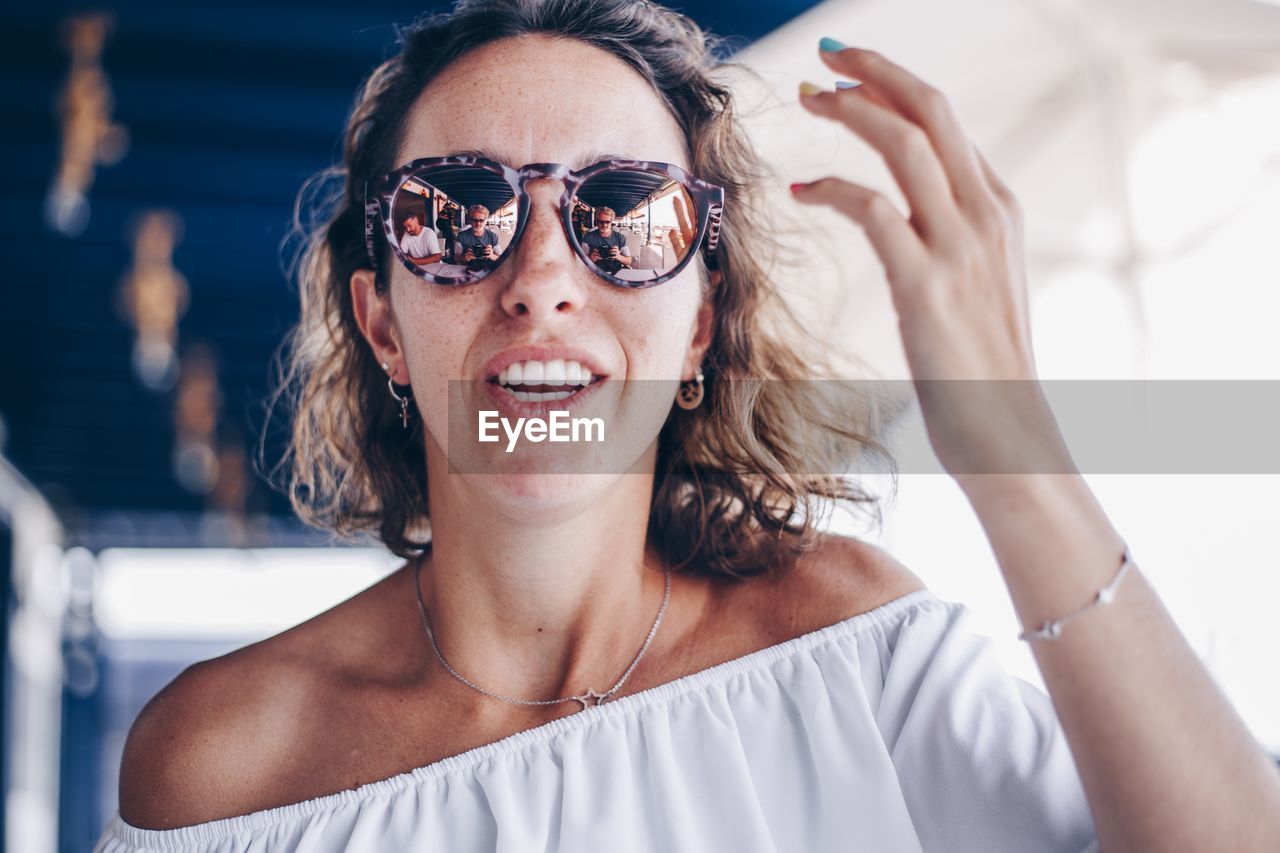 Portrait of smiling young woman wearing sunglasses