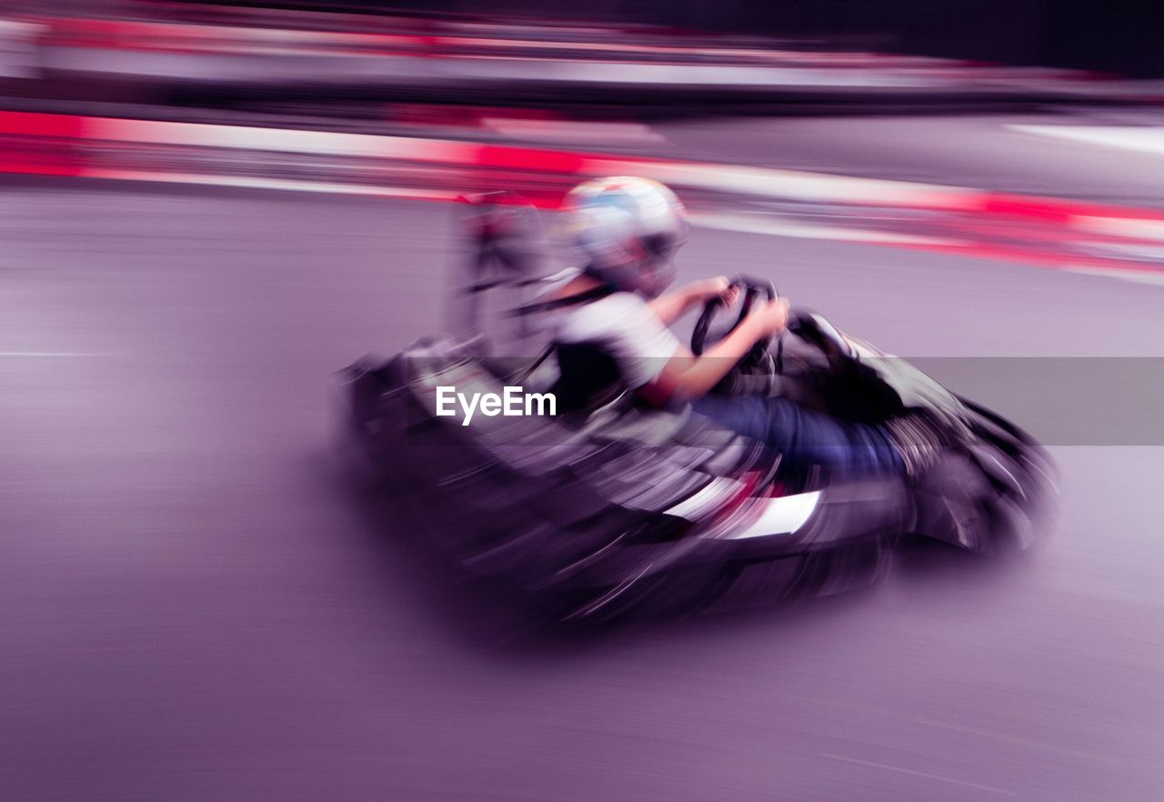 Blurred motion of man go-carting
