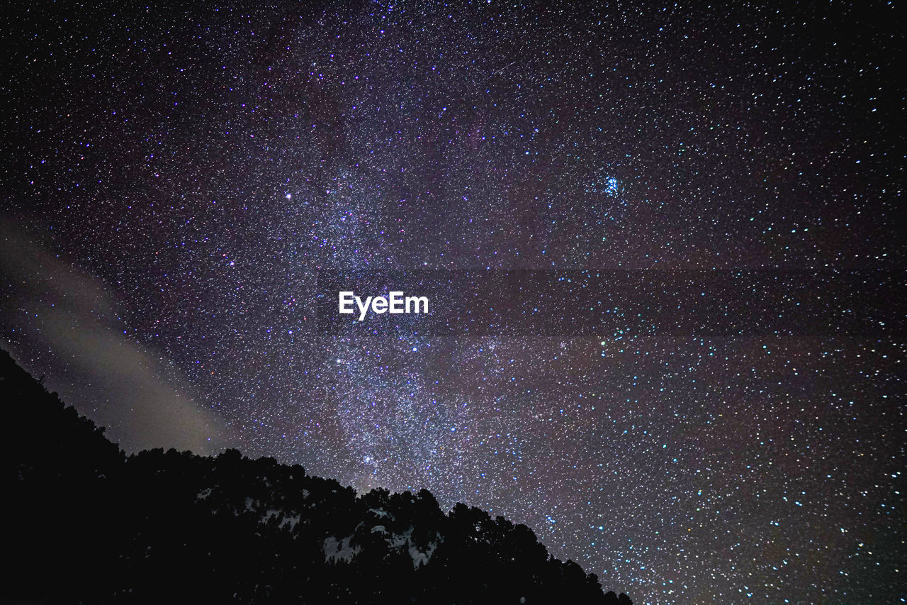 Low angle view of star field against sky at night 