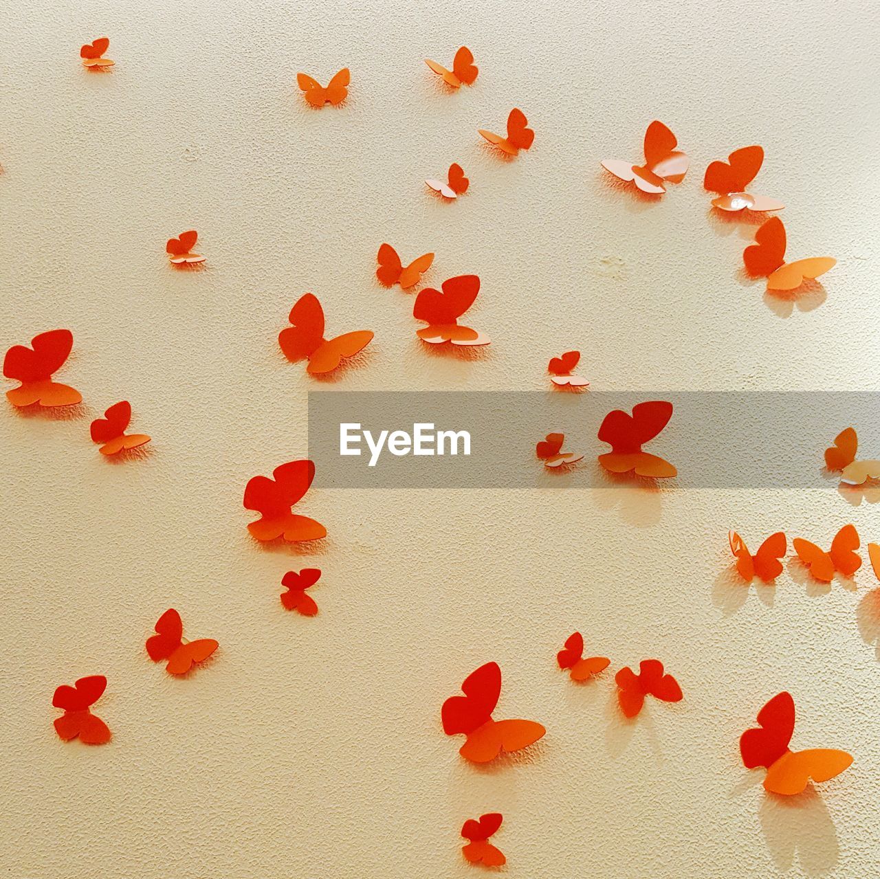 Orange artificial butterflies on wall