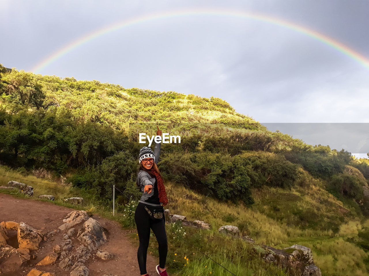 FULL LENGTH OF PERSON STANDING ON FIELD AGAINST RAINBOW