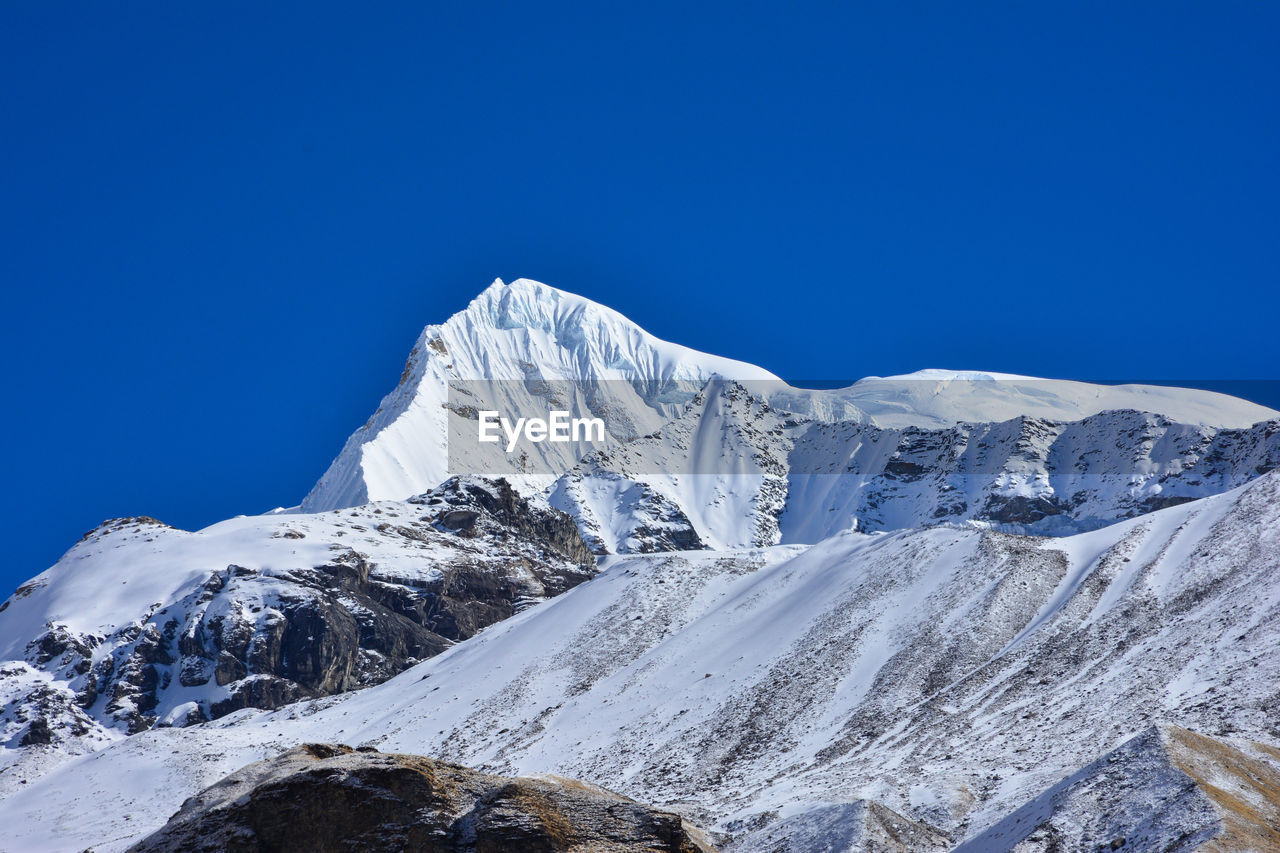 Scenic view of snowcapped mountains against clear blue sky, annapurna