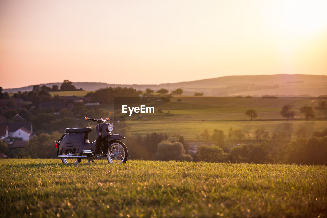 Motorcycle on countryside landscape against clear sky