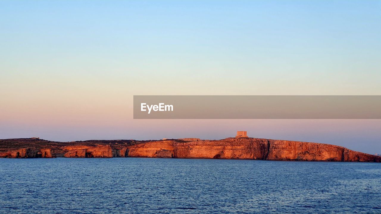 Scenic view of sea against clear sky during sunset