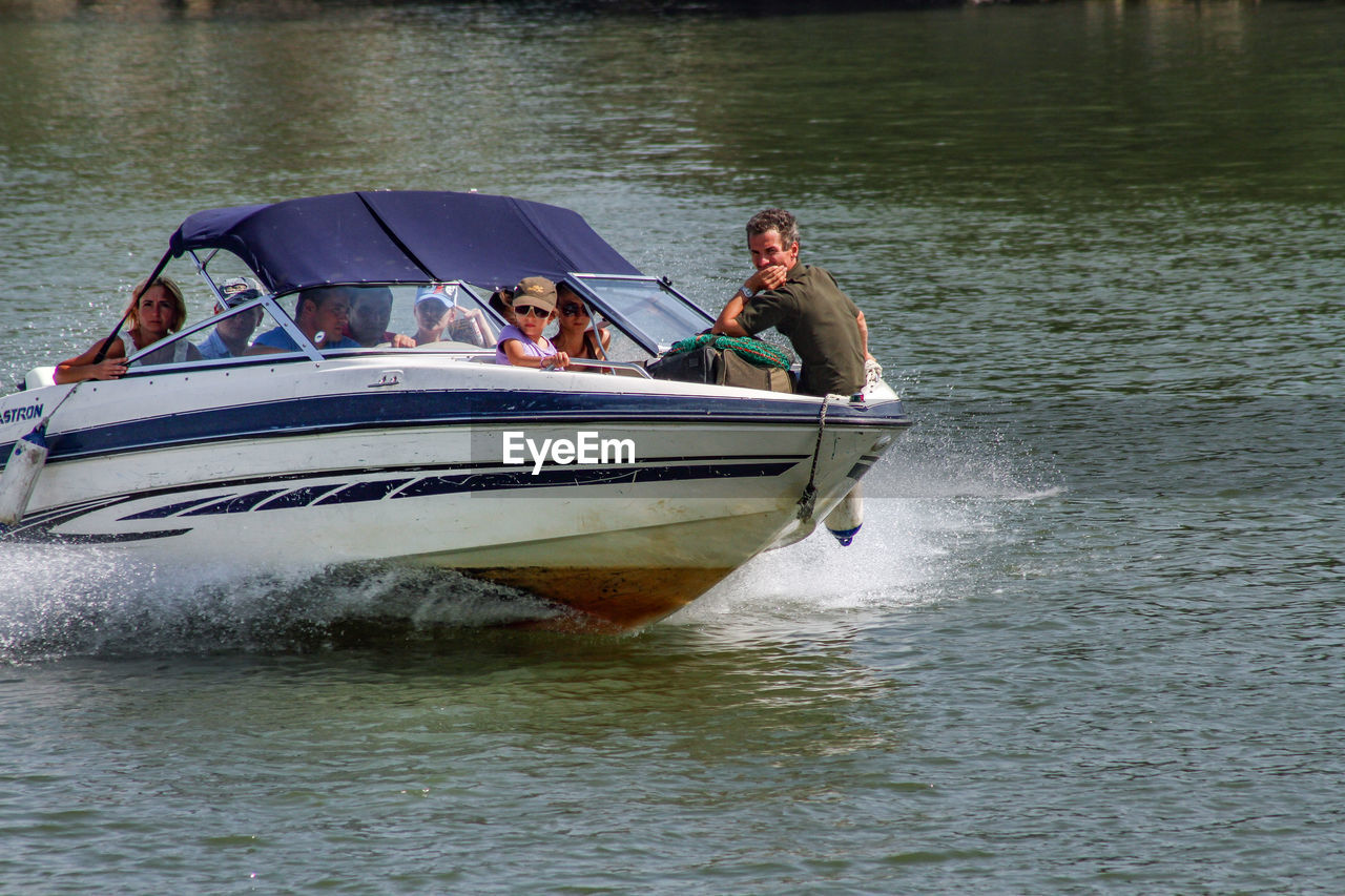 PEOPLE IN BOAT SAILING IN RIVER