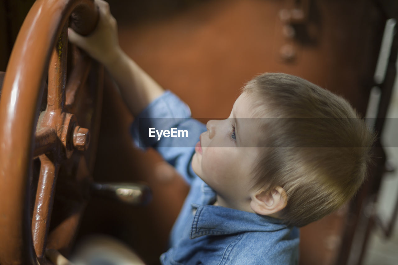 High angle view of toddler with steam train wheel