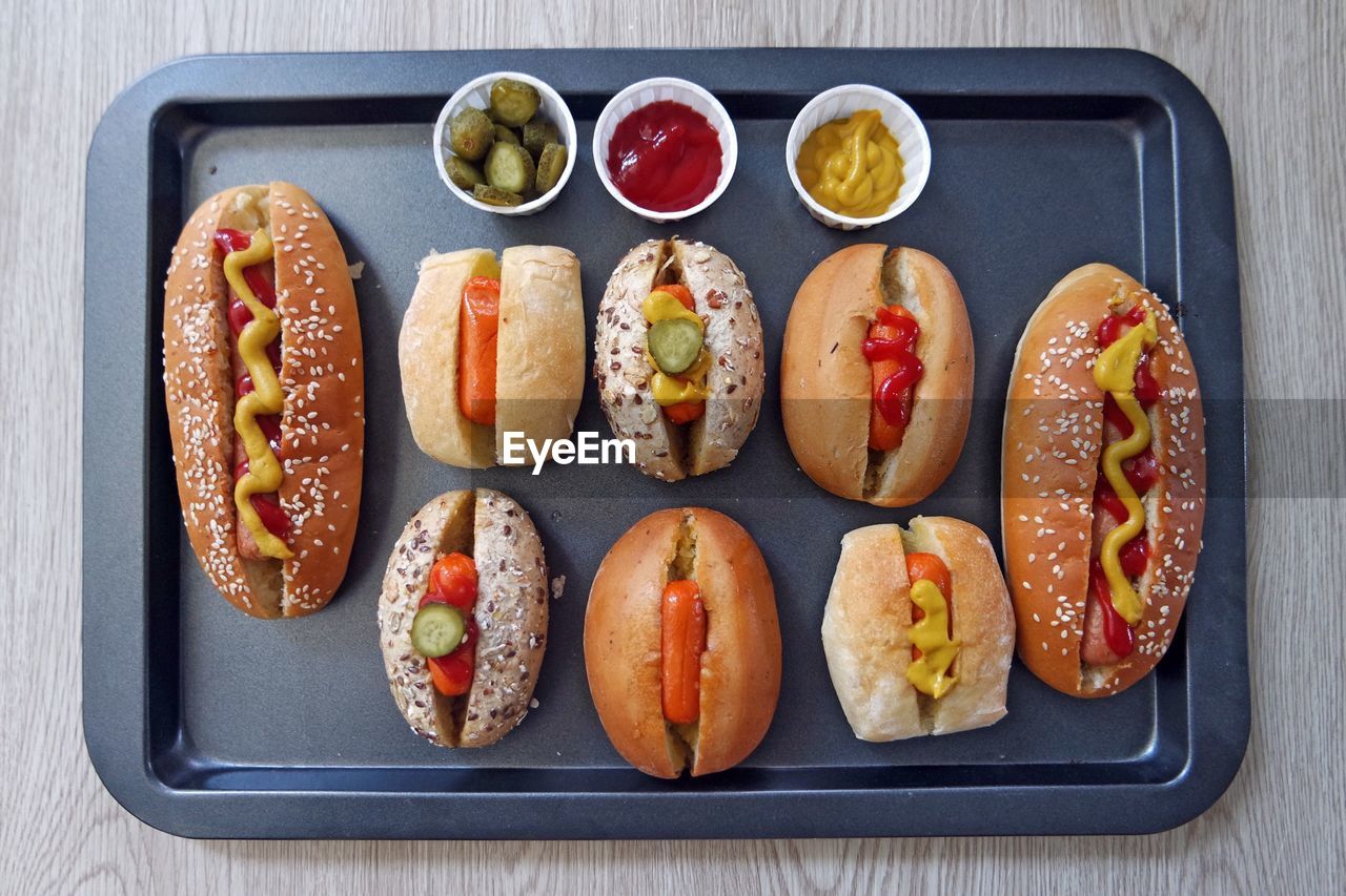 Directly above shot of homemade hot dogs in serving tray on table