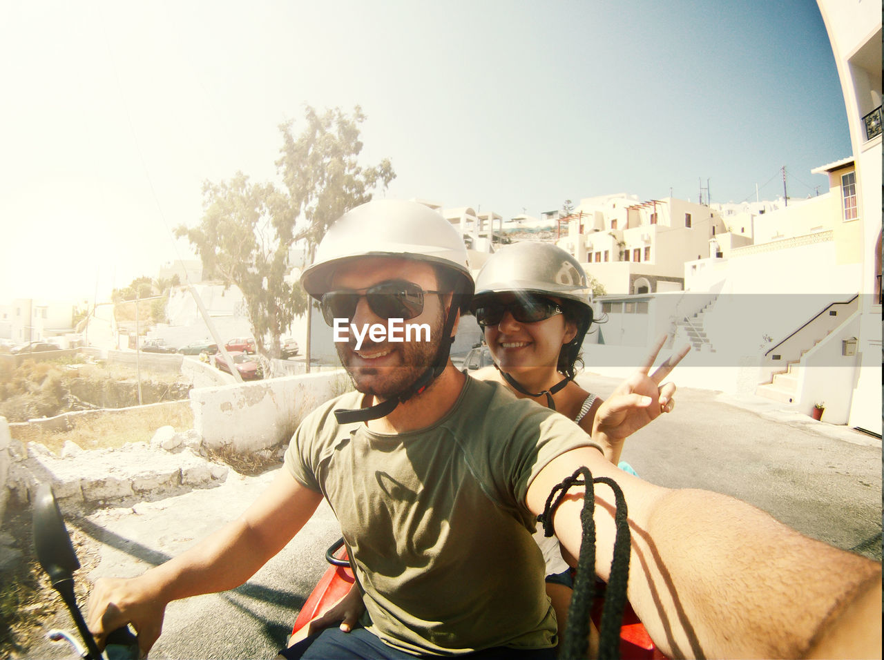 Smiling couple doing selfie while riding on motorcycle
