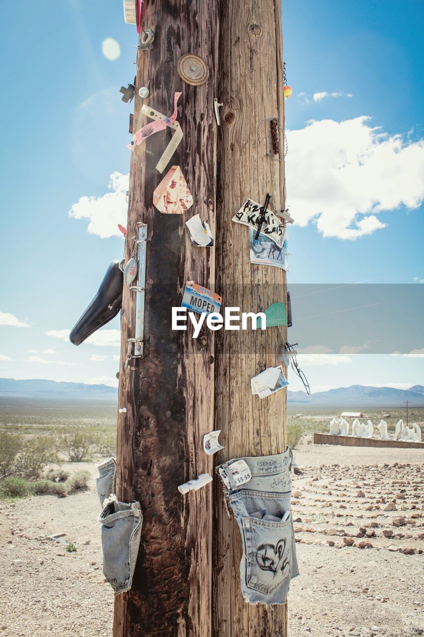 Papers and signs on wooden post at nevada desert