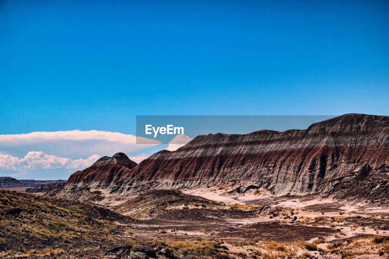 Scenic view of mountains against blue sky