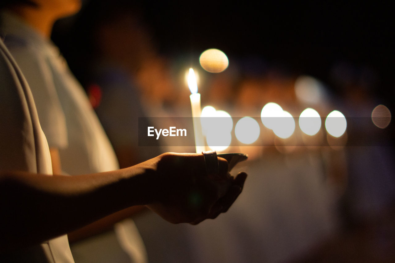 CLOSE-UP OF HAND HOLDING CANDLES