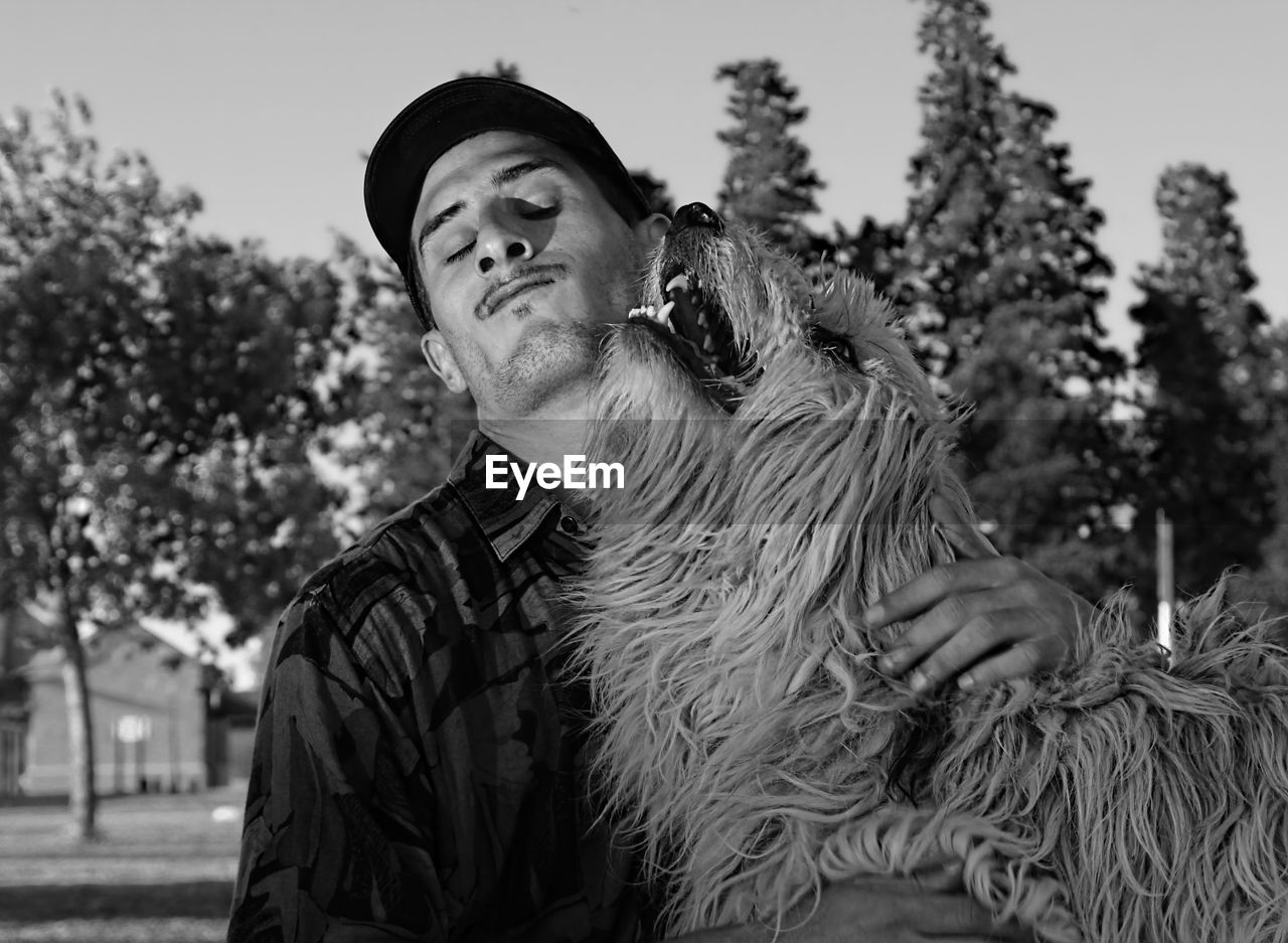 Man playing with hairy dog in park