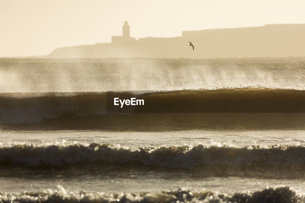 Scenic view of sea waves during sunny day