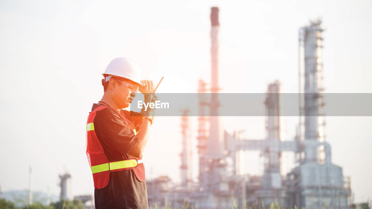 Engineer standing at construction site against sky