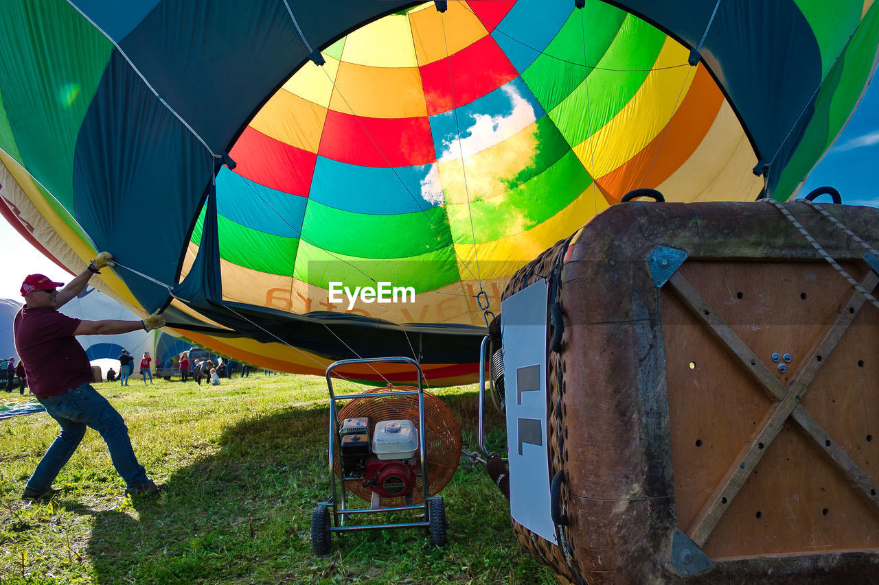 REAR VIEW OF HOT AIR BALLOON ON FIELD