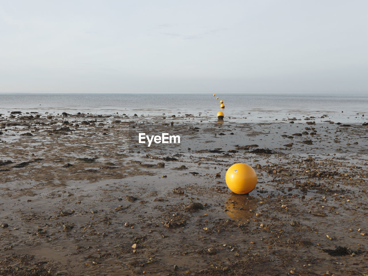 YELLOW FLOATING ON WATER AGAINST SKY