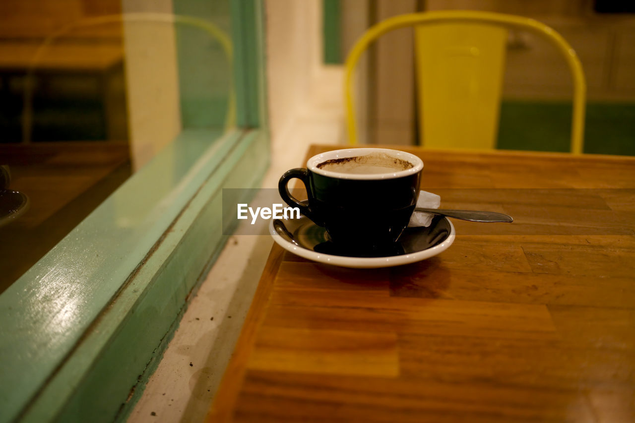 COFFEE CUP WITH TEA ON TABLE