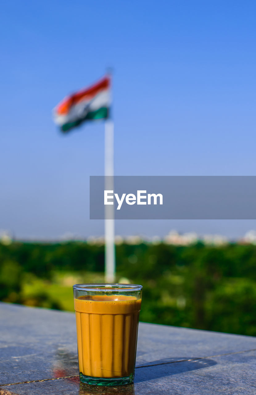 Tea in glass on retaining wall against indian flag