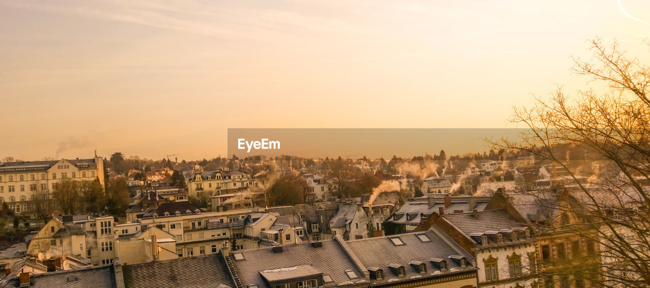 High angle view of buildings in city at sunset