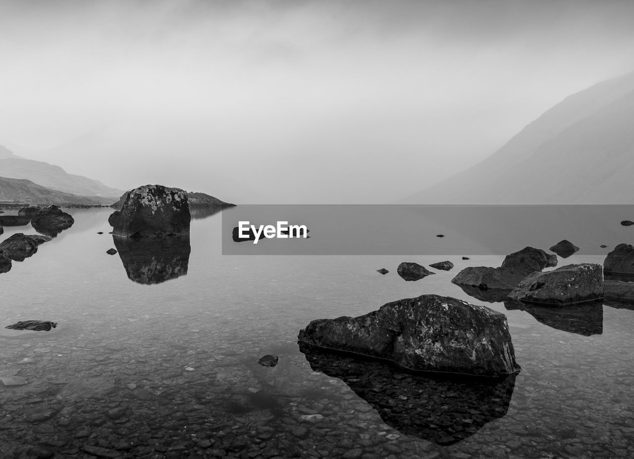 Rocks by sea against sky