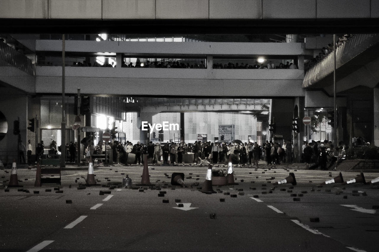 GROUP OF PEOPLE IN ILLUMINATED CITY