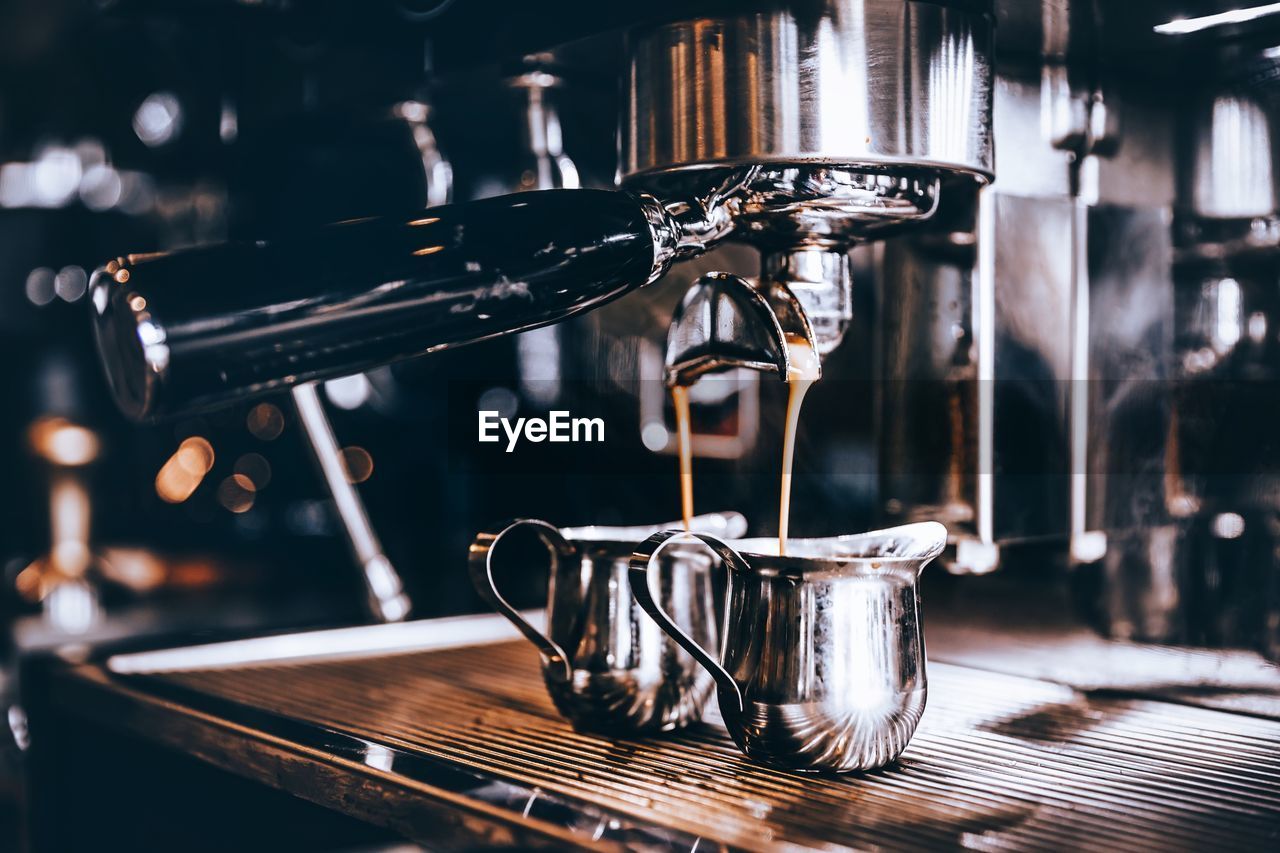 food and drink, coffee, drink, coffeemaker, espresso maker, espresso machine, refreshment, coffee shop, indoors, cafe, coffee cup, cup, mug, no people, machinery, metal, appliance, close-up, drums, pouring, household equipment, focus on foreground, home appliance, making