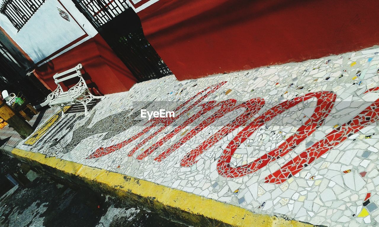 Tilt shot of mosaic text on footpath in city