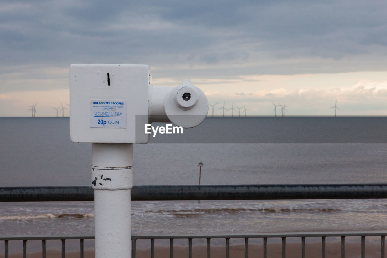 Information sign on sea against sky