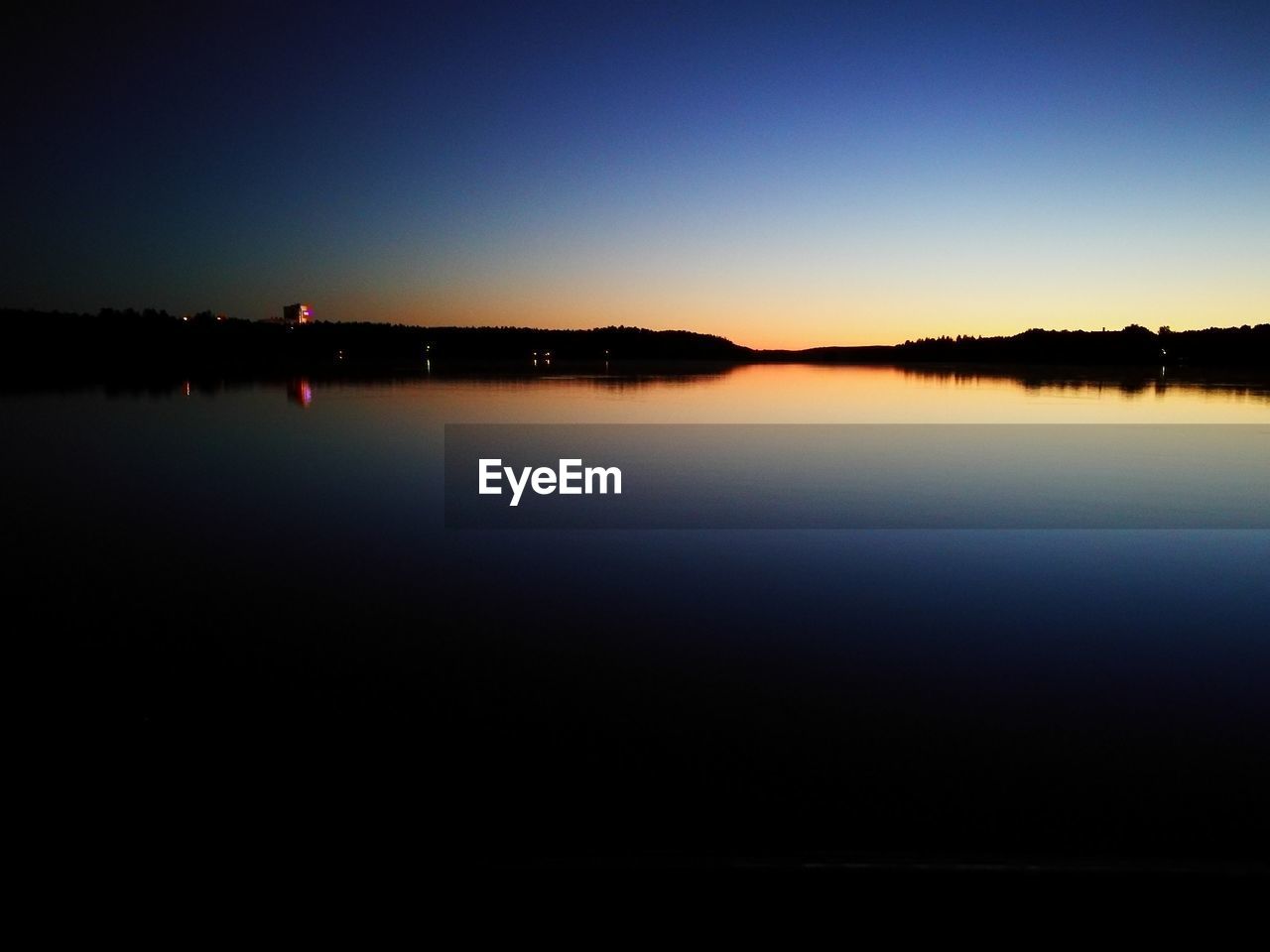 Scenic view of lake against clear blue sky