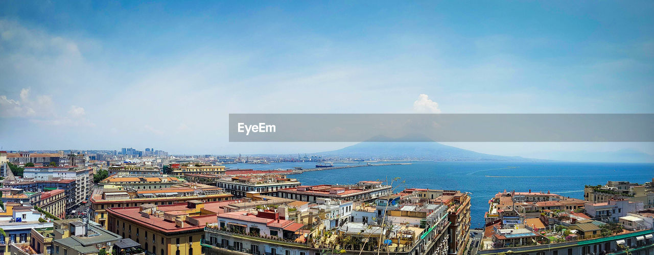 High angle view of buildings by sea against sky