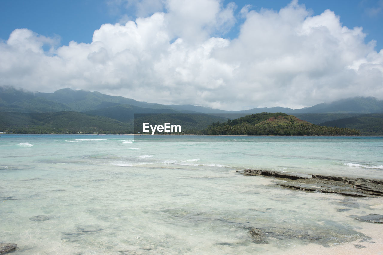 Scenic view of sea and mountains against sky