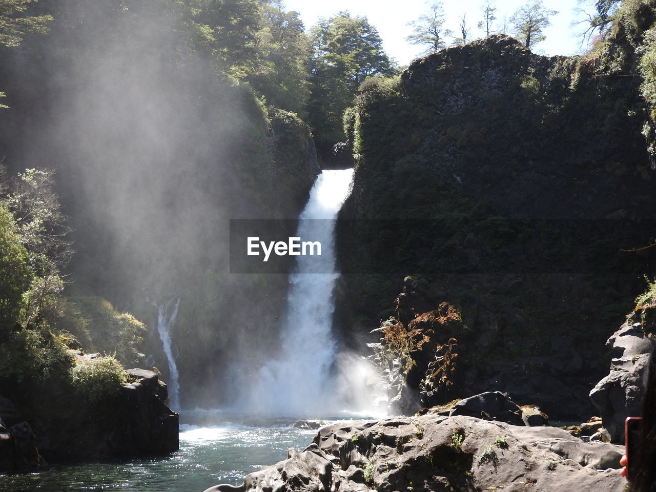 SCENIC VIEW OF WATERFALL AGAINST TREES