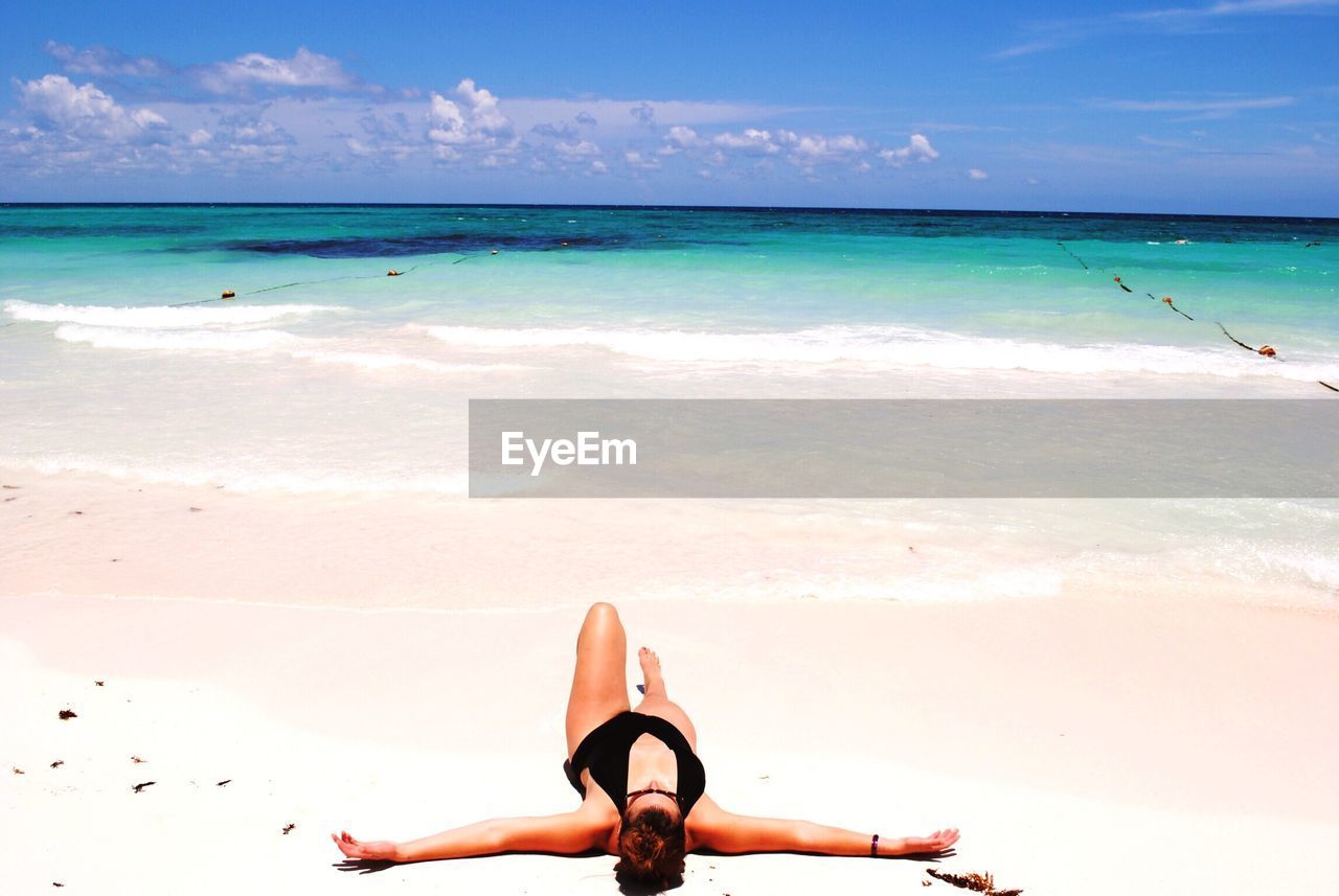 Woman at beach against sky