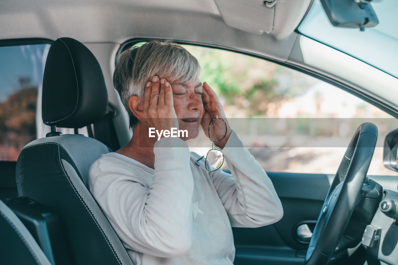 Side view of woman sitting in car