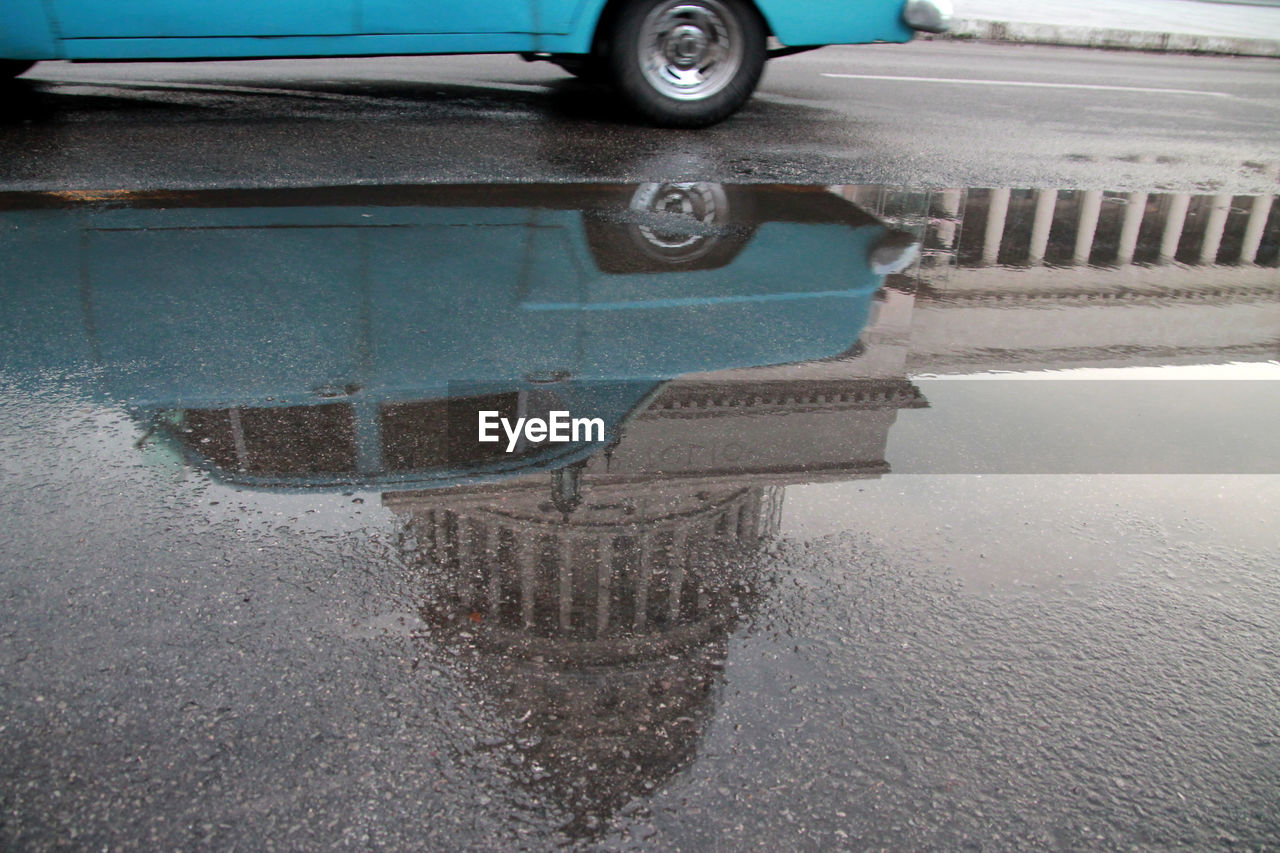 Reflection of car in puddle on road