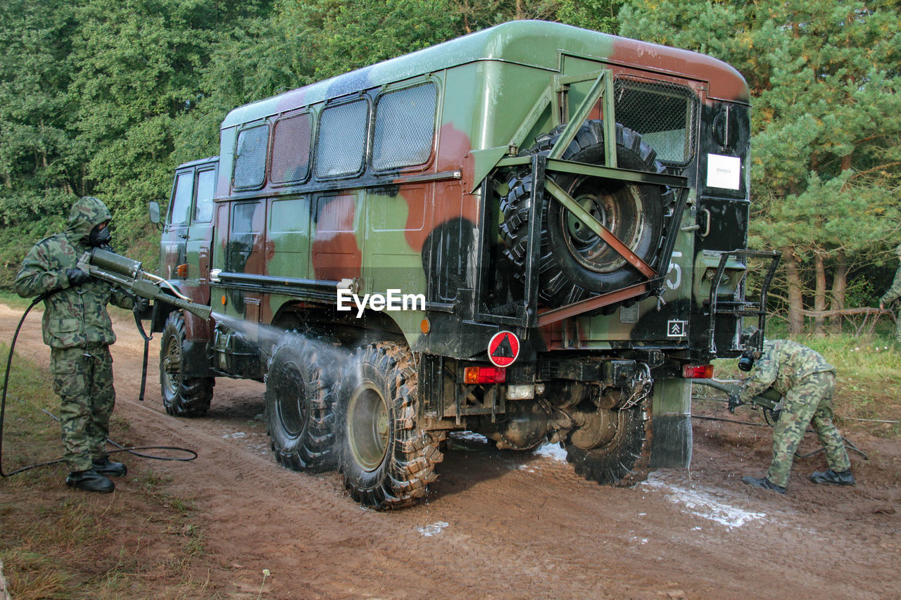 Men cleaning truck on field