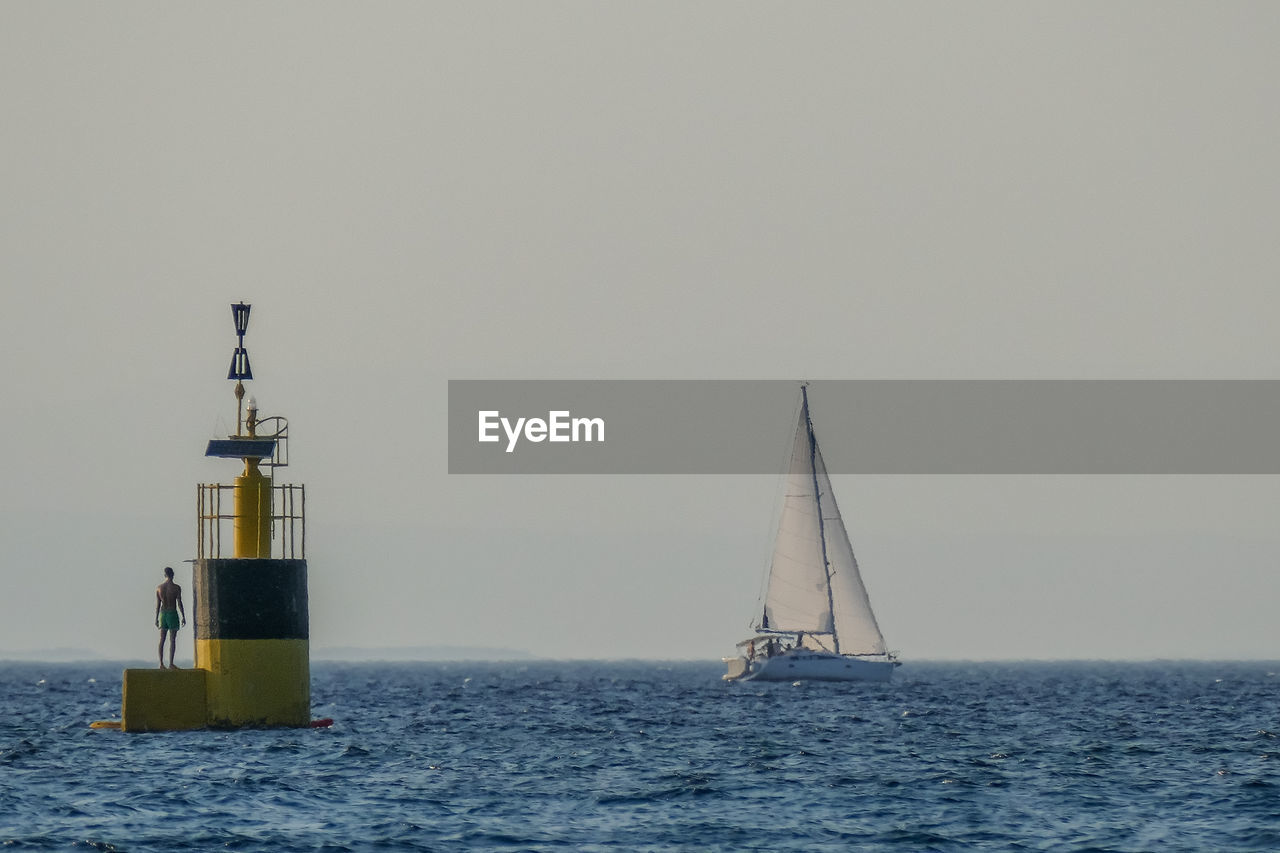 SAILBOAT ON SEA AGAINST CLEAR SKY