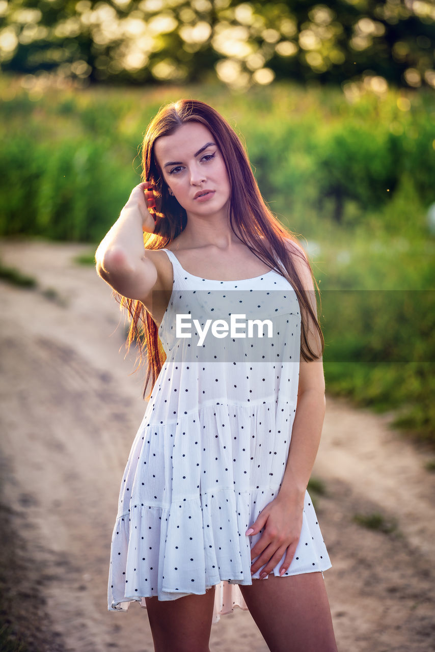 women, one person, young adult, long hair, hairstyle, adult, fashion, portrait, summer, smiling, nature, clothing, happiness, emotion, dress, female, standing, lifestyles, brown hair, child, teenager, beauty in nature, three quarter length, outdoors, casual clothing, spring, photo shoot, tree, cheerful, plant, looking at camera, relaxation, arts culture and entertainment, land, positive emotion, portrait photography, leisure activity, sunlight, springtime, yellow, blond hair, person, sunset, front view, looking, pink, childhood, cute, focus on foreground, forest, day, copy space, redhead, rural scene, park - man made space