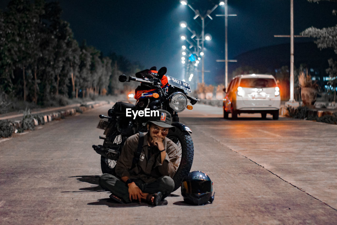 MAN RIDING MOTORCYCLE ON ROAD