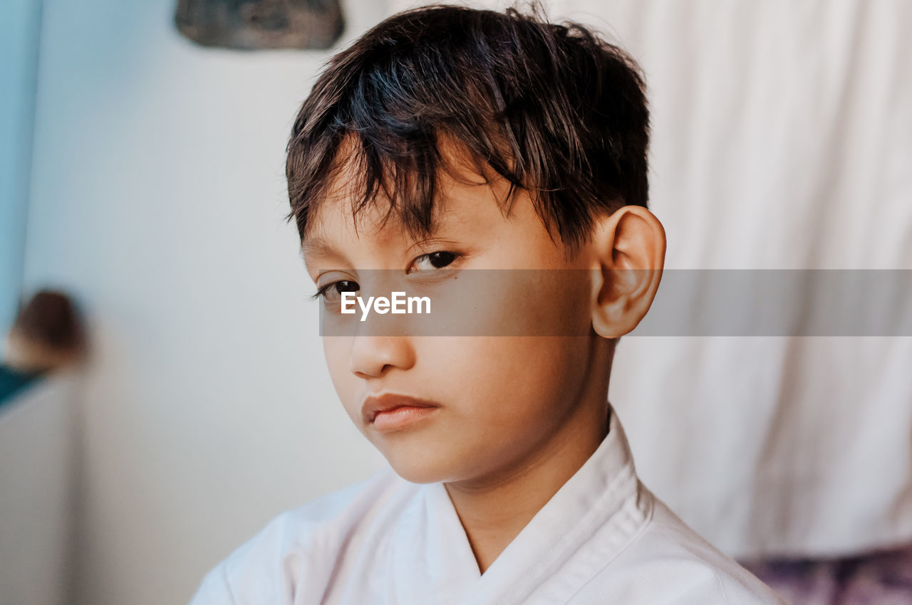 Close-up portrait of sulking boy at home